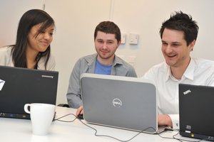 Zwei Männer und eine Frau arbeiten und lernen am Computer
