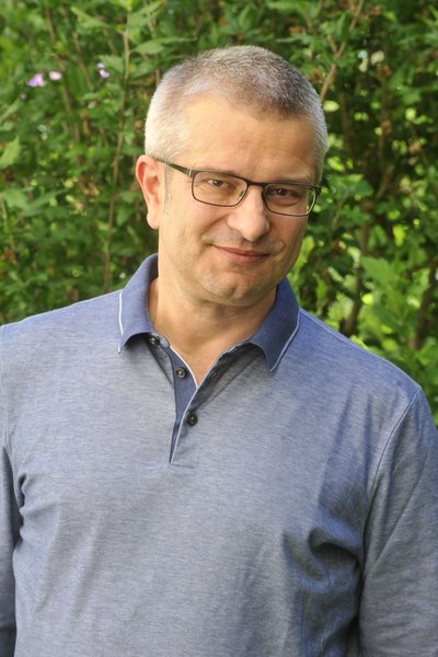 Mann mit Brille und grauem, sehr kurzen Haar