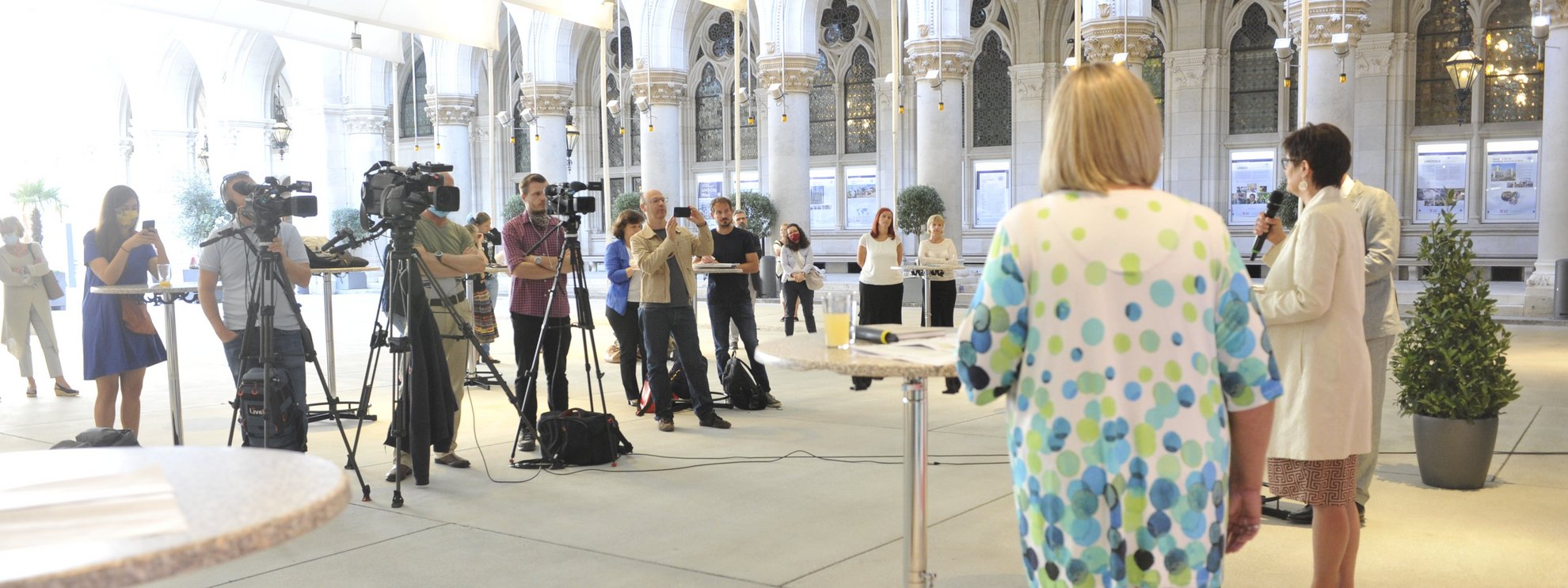 Pressekonferenz-Setting im Arkadenhof des Wiener Rathauses mit Diskutanten und vielen Kameras